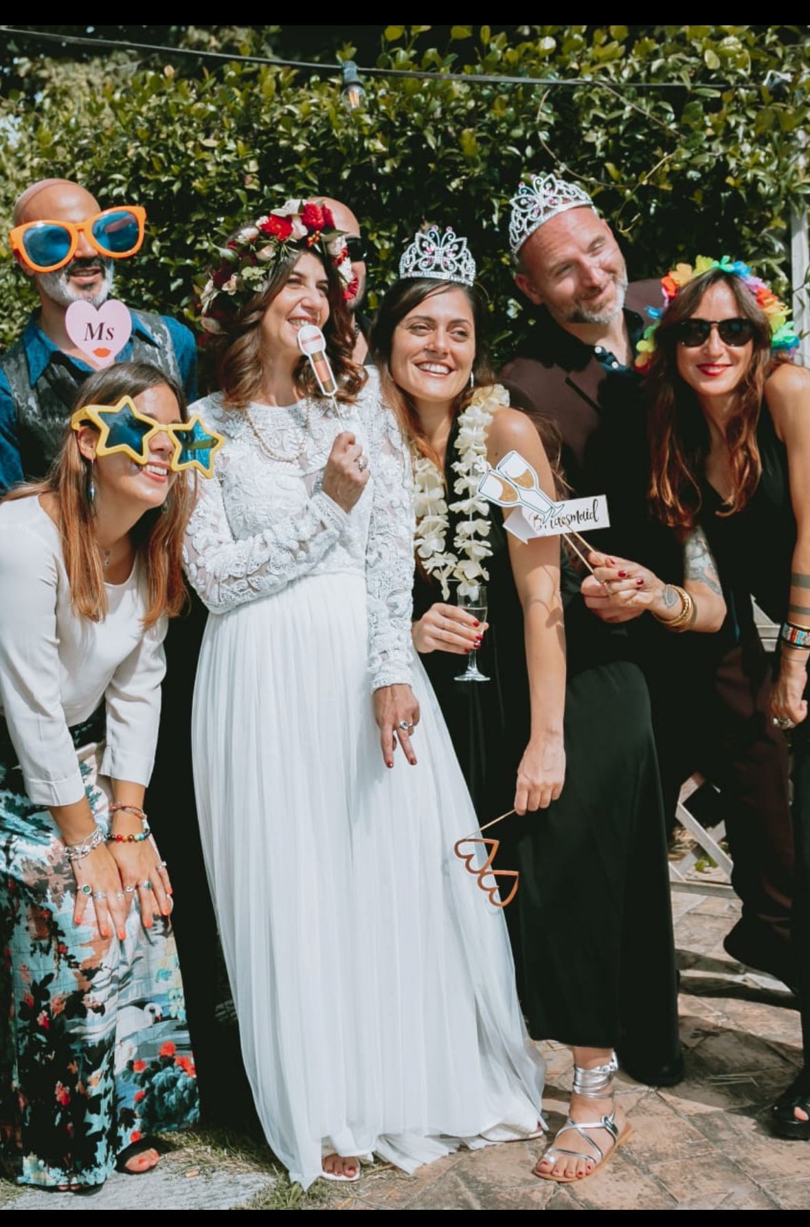 Sposa e invitati con oggetti scenici per la foto