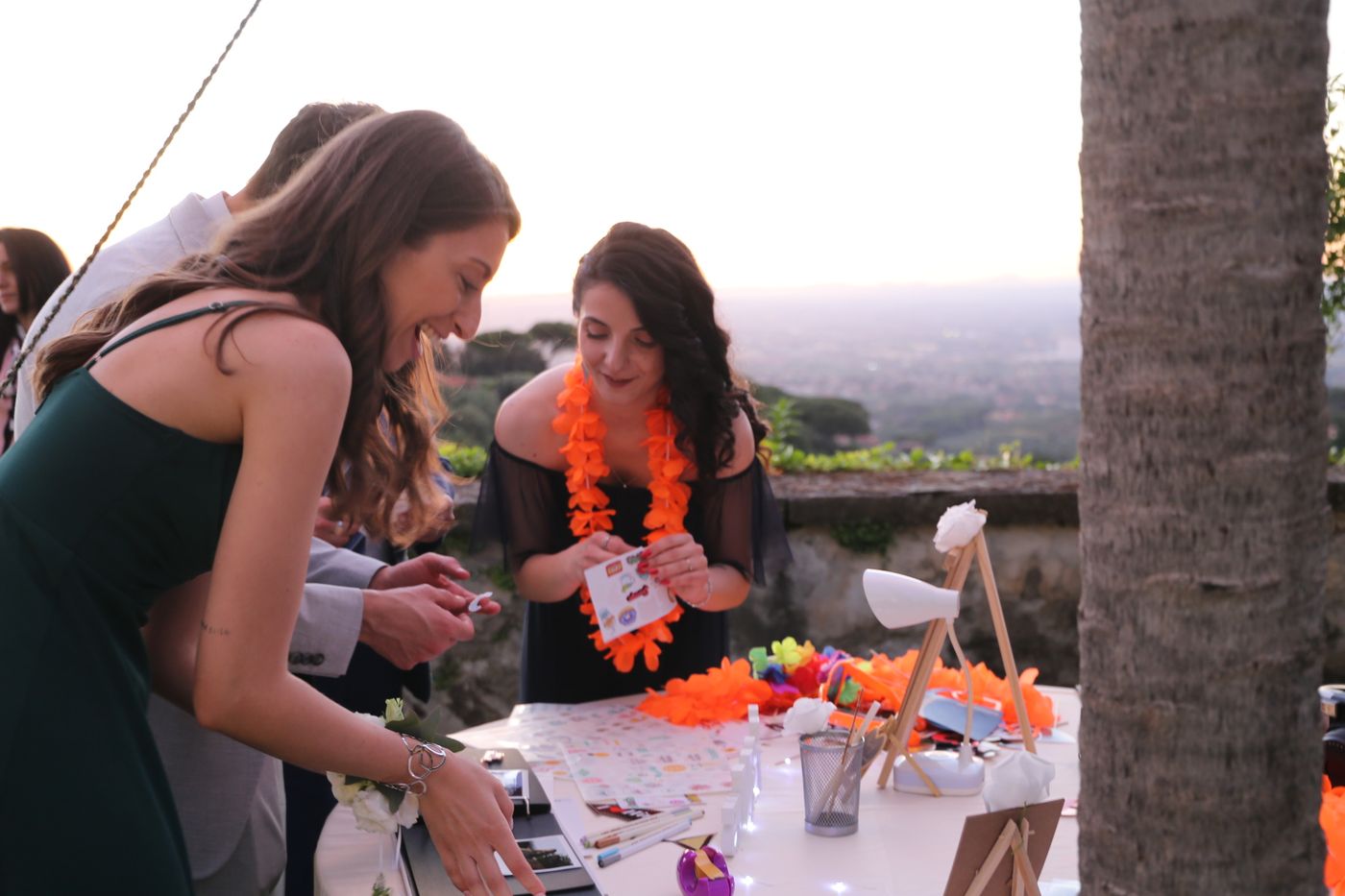 Invitati decorano una polaroid al tramonto durante un matrimonio